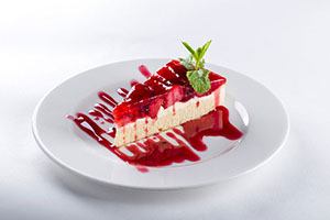Strawberry cheesecake with berry coulis drizzle