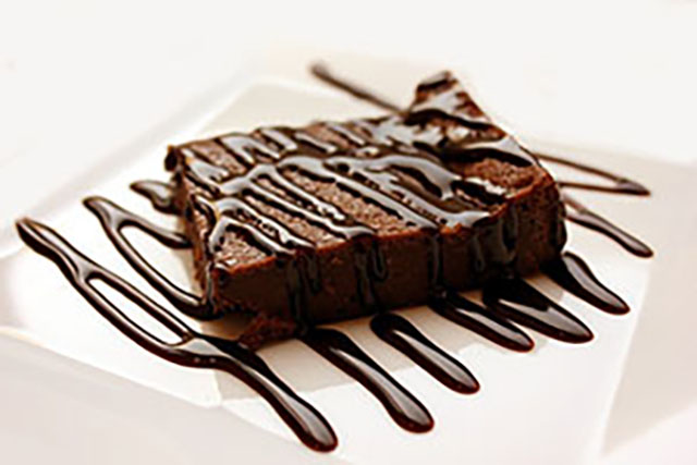 Chocolate brownie with chocolate drizzle, on a plate